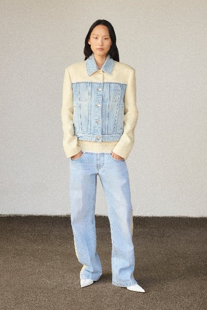小孩穿着蓝色的衣服站在墙边 中度可信度描述已自动生成