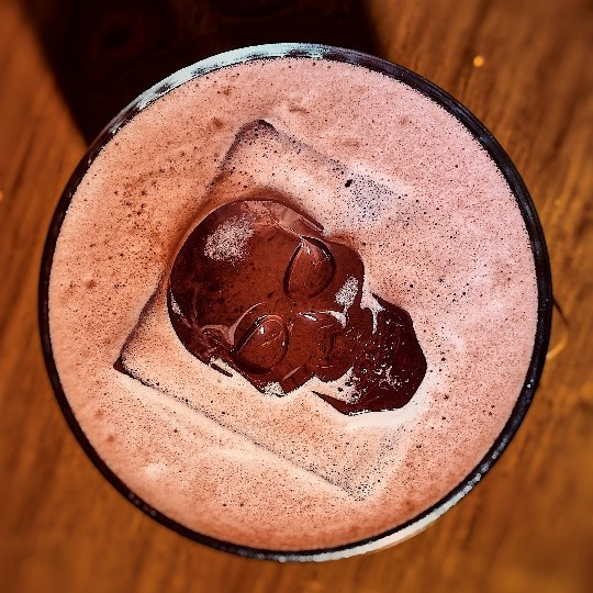 A glass of liquid with a skull in it Description automatically generated
